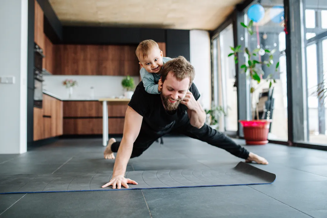 Father holding child on his back during workout