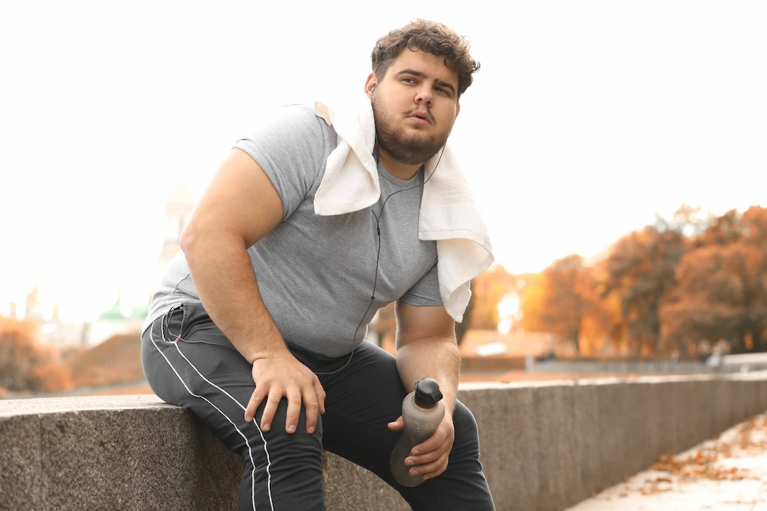 Plus size man holding water bottle