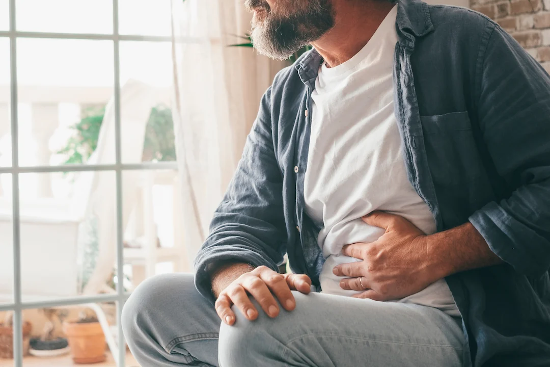 Mature man holding stomach in pain