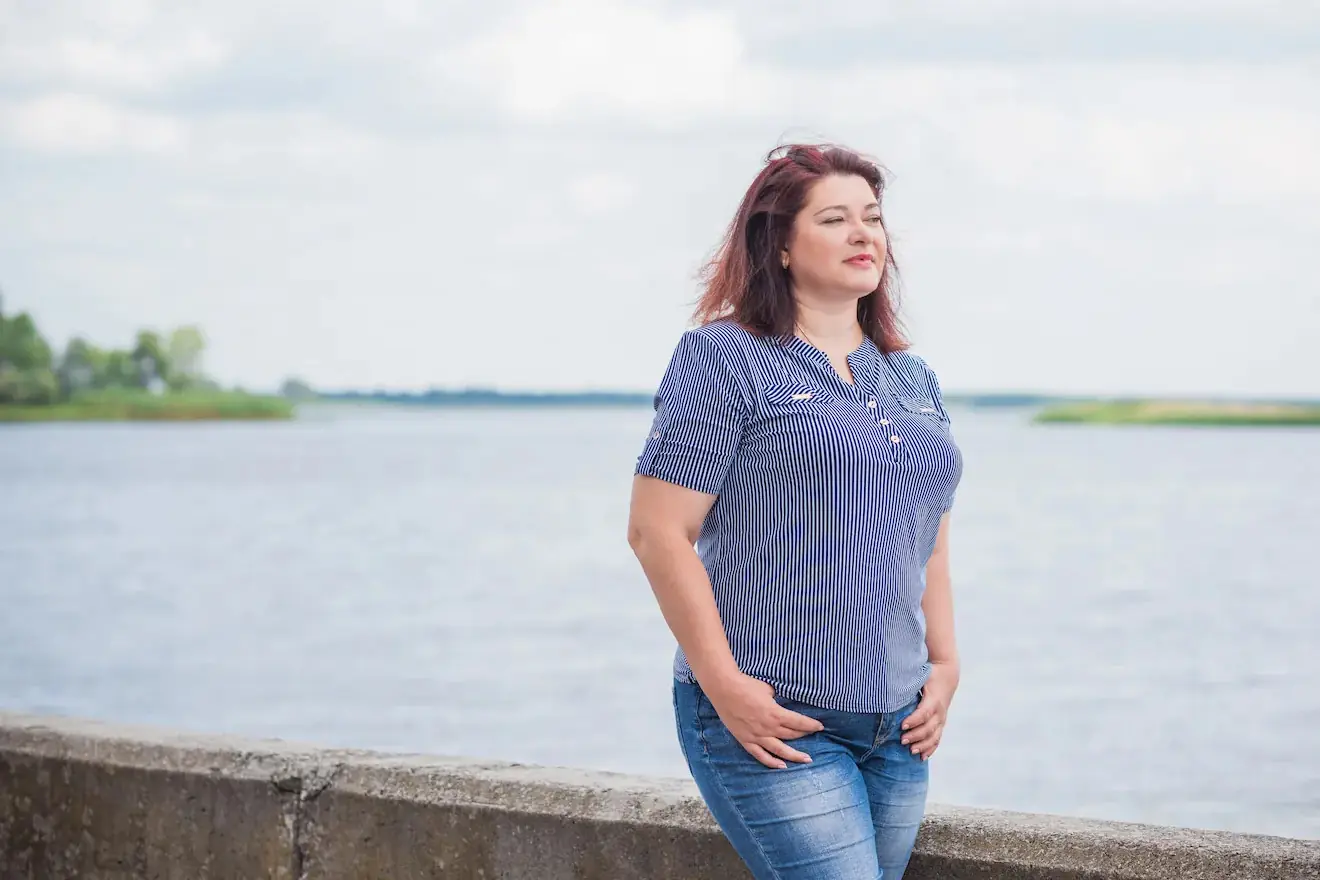 Plus size woman standing by the water