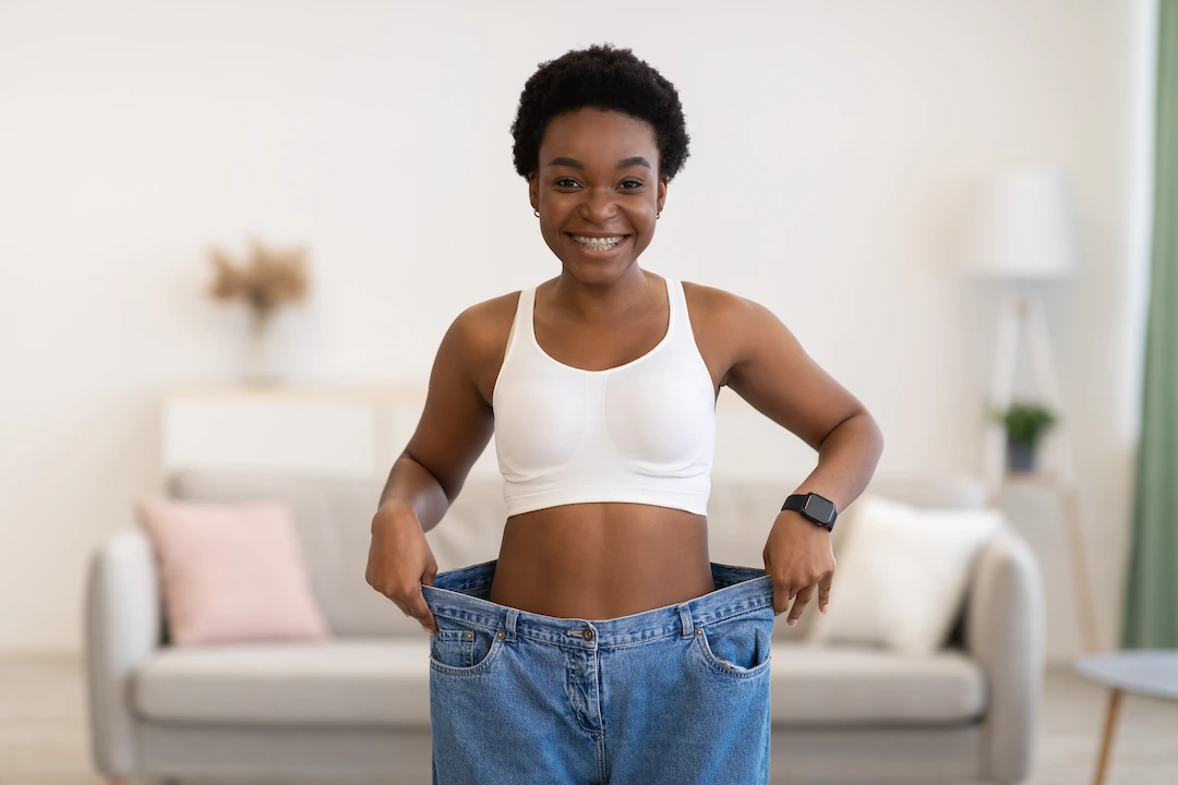 Woman in oversized jeans after great weight loss