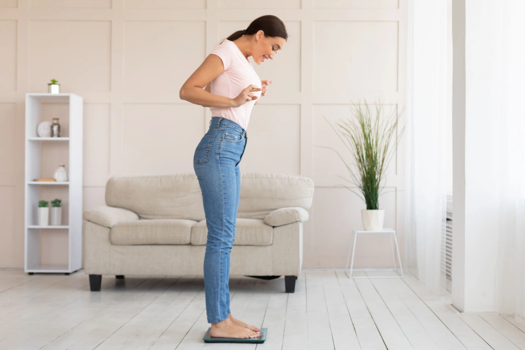 woman weighing herself on scale