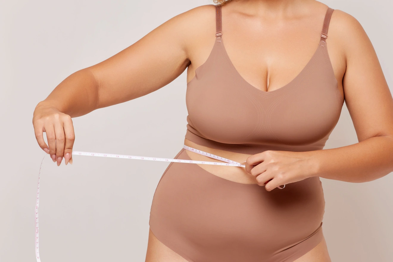 woman measuring her waist after weight loss surgery
